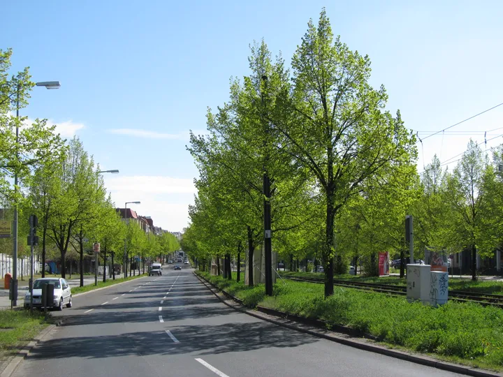 A wide street running east from a bridge between apartment blocks.
