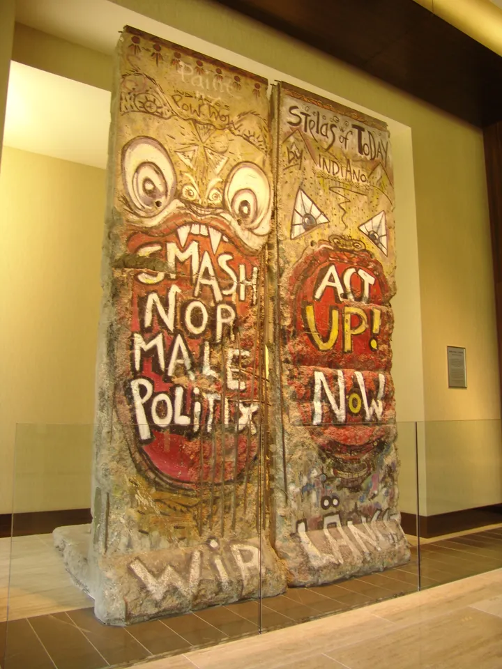 Two painted Berlin Wall segments standing in an indoor sculpture garden.