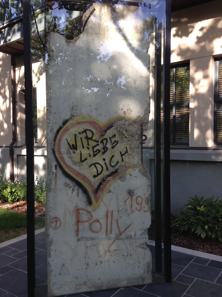 A painted Berlin Wall section standing outside a public library.