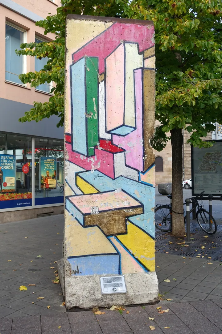 A painted Berlin Wall segment standing outdoors.