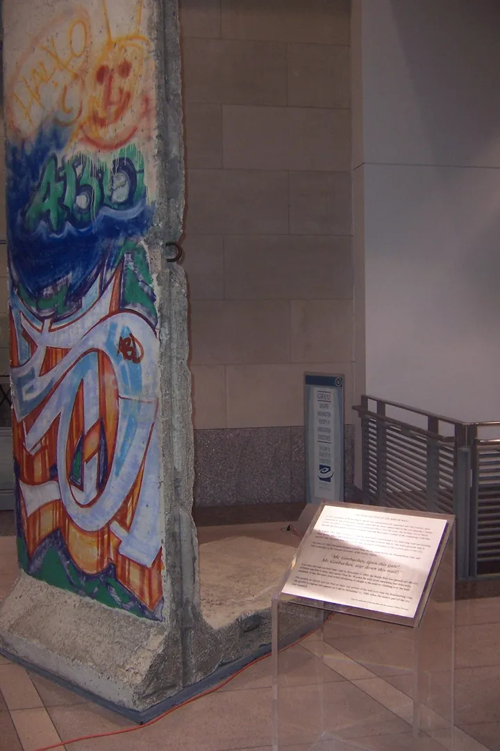 A painted Berlin Wall segment standing indoors in a building lobby.