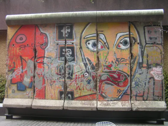 A painted Berlin Wall segment on a Manhattan street beside Paley Park.